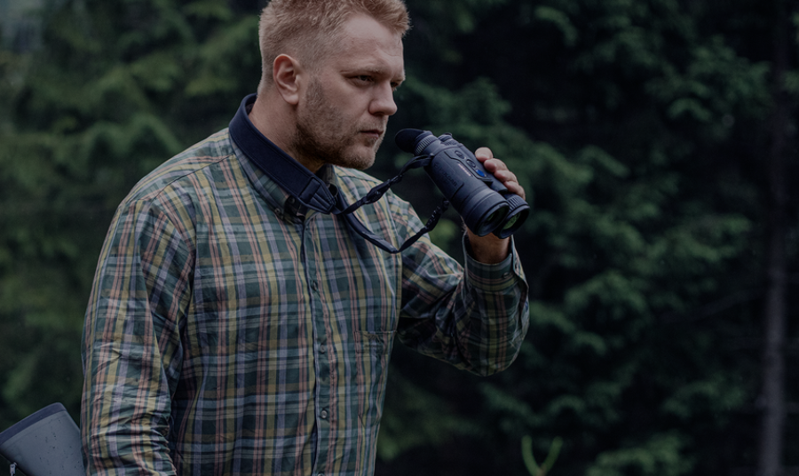 Man looking through thermal binoculars